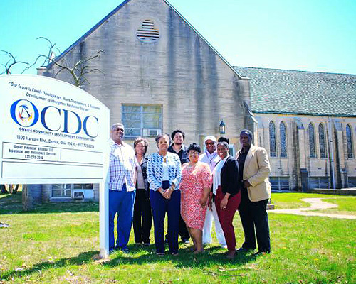 group standing by Omega CDC sign outside of a church